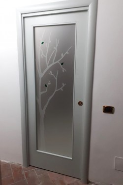 Porta in vetro satinato con decoro sabbiato e particolari verniciati traslucidi