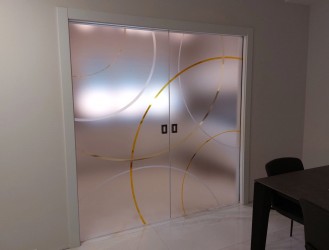 Porta in vetro satinato con decoro sabbiato e particolari verniciati traslucidi
